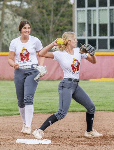  Farmington Hills Mercy junior Kat Burras makes a throw  during a team practice with sophomore Kaitlyn Pallozzi pictured  in the background.  