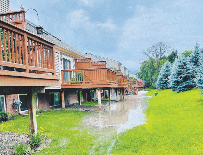  Flooding occurs on the northern end of the property at the Windmill Pond condo development on 22 Mile Road, just west of Hayes Road, during the early evening July 2. 