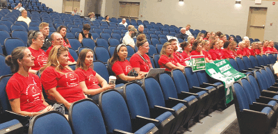  Grosse Pointe Public School System teachers, in matching red Grosse Pointe Education Association T-shirts, attend the July 25 Grosse Pointe Board of Education meeting at Brownell Middle School to show solidarity as they seek a new contract. 