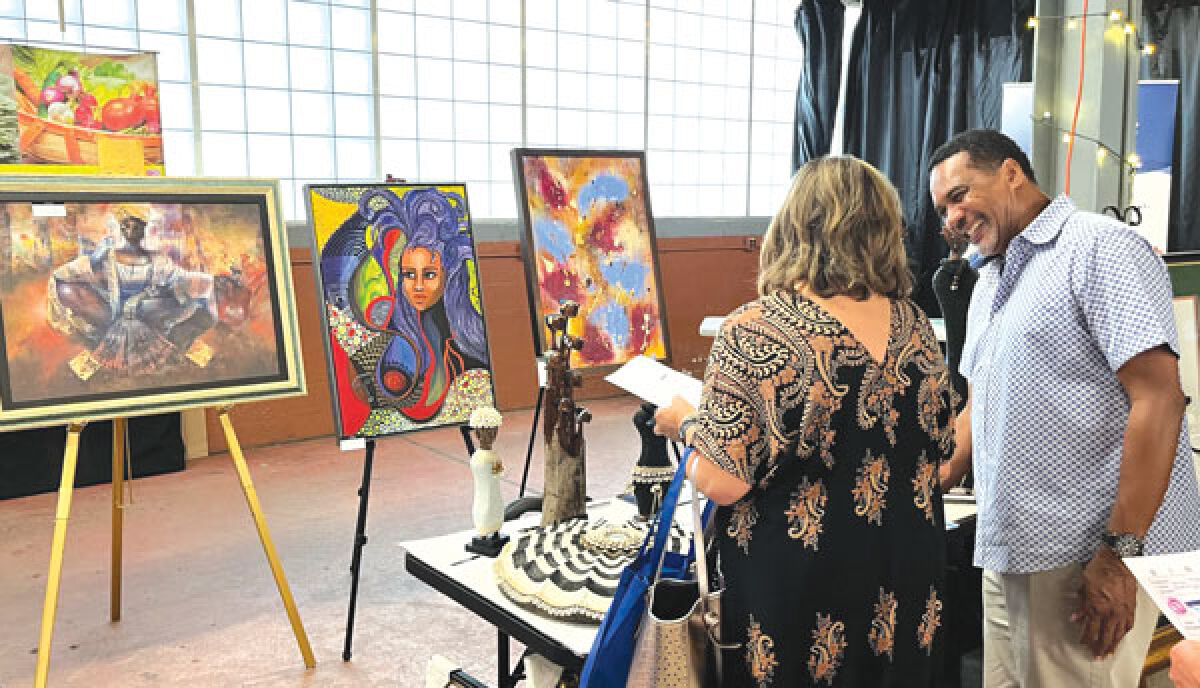  Ian Grant, the owner of Umoja Fine Arts Gallery in Southfield, tells visitors about his business at the 2023 Diversity Expo hosted at the Royal Oak Farmers Market July 25. 