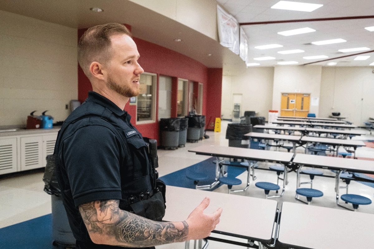  Officer Nick Lienemann of the Warren Police Department walks through the halls of Cousino High School on June 2. Lienemann is one of several Warren officers who serve as a school resource officer in the Warren Consolidated Schools district.  