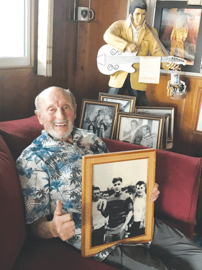  Johnny Lang holds up the photo of himself and Elvis Presley playing football while stationed in Germany. Lang, of Harrison Township, is pictured on the right with Presley in the center.  