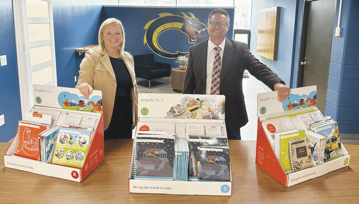  Heather Halprin, Clintondale Community Schools chief academic officer, left, and Ken Janczarek, Clintondale superintendent, stand with a collection of books designed to work with the district’s new elementary language arts curriculum. 