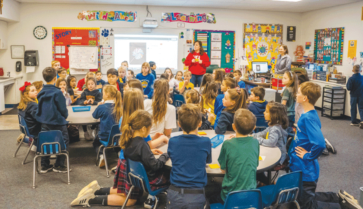  Kathy Guirey, center, a first-grade teacher at Our Lady of Victory Catholic School in Northville, teaches students in class during a previous school year. 