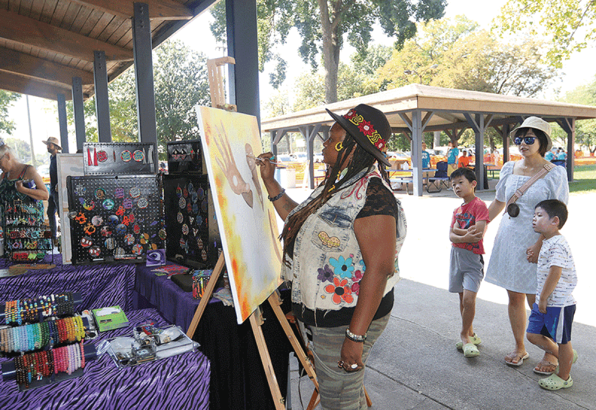  An artist with Naye Taye Visuals works on a print at last year’s Hazel Park Art Fair. This year’s event is Aug. 26-27, once again at Green Acres Park. 