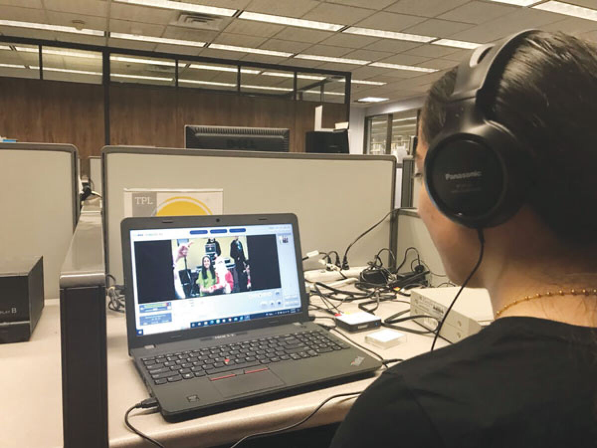 Troy resident Noor Hadad converts an 8 mm recording of a family Christmas celebration into a digital format at the Troy Public Library’s Memory Lab. 