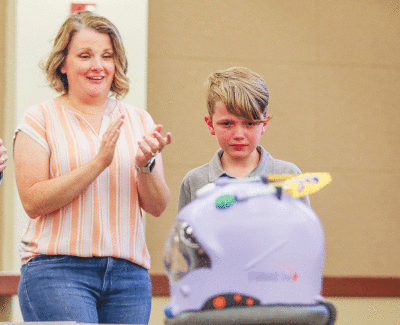  Masonic Heights Elementary fourth grade student Madeline Calappi and her mom, Rebecca Calappi, get a first look at the “utensil helmet” prototype during the celebration June 9 at the Macomb Intermediate School District in Clinton Township.   