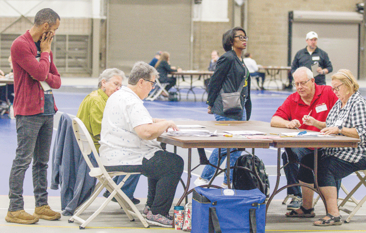  Jocelyn Howard, standing at center, requested a recount of some precincts in the primary race for the Warren City Council’s two at-large seats. Observer Michael Howard (no relation), standing at left, watches as the recount is conducted. 