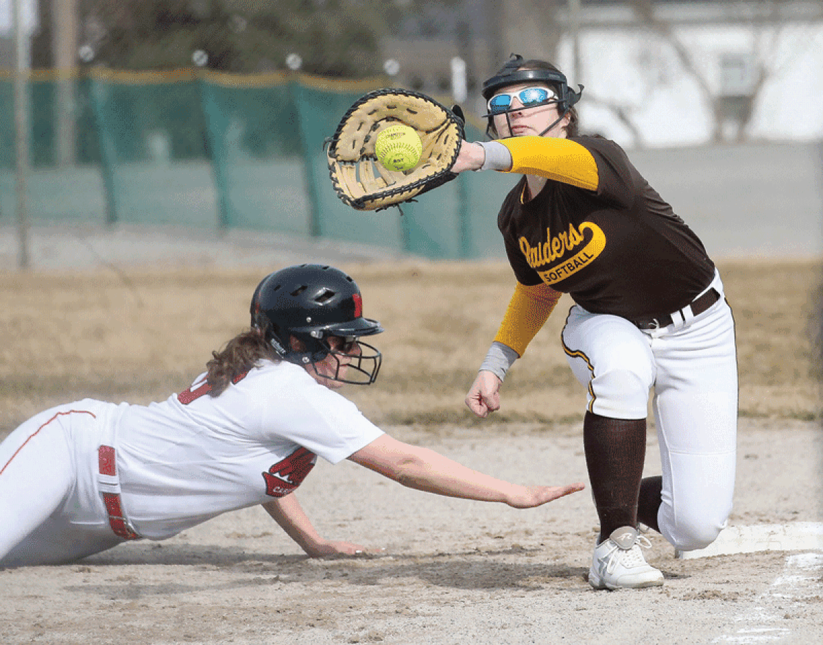  North Farmington senior first baseman Jordyn Taylor (8) tries to pick off the runner with a throw from the catcher in a 2019 game. 