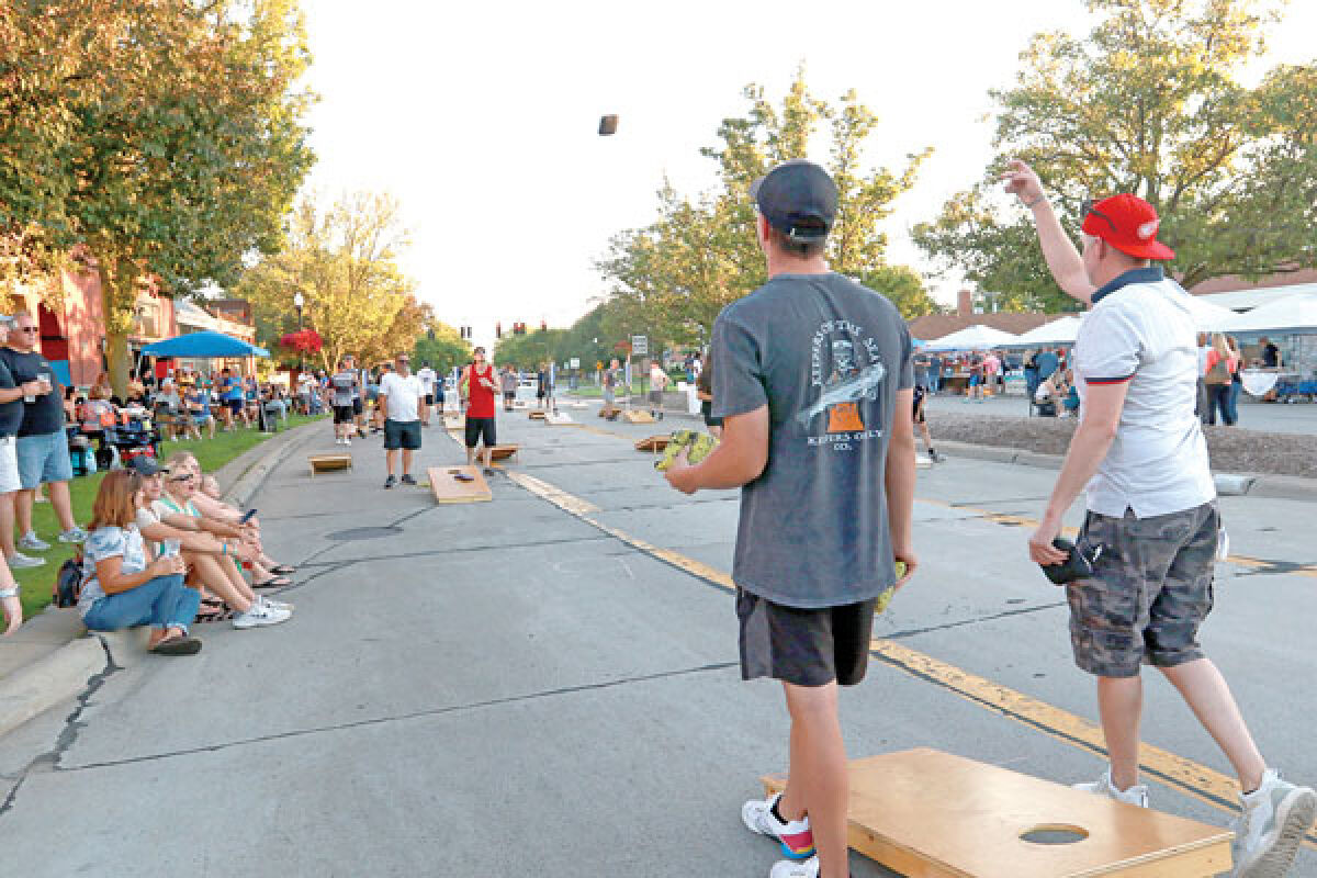  Patrons of the Downtown Social District participate in the cornhole tournament on Aug. 12. 