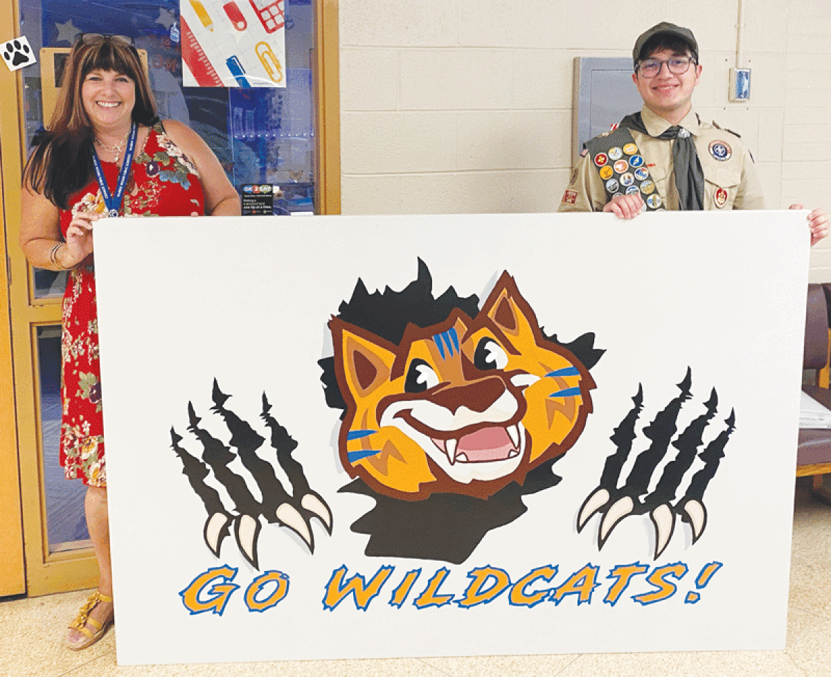  Eagle Scout Sami Beauchamp, right, presents Westwood Elementary School Principal Melissa Johnson, left, with the artwork he made of the school’s Wildcats mascot. 