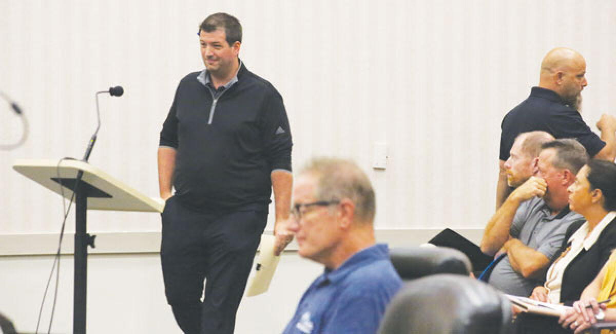  Macomb Township resident James Grahek takes to the podium during the public comment period at the Aug. 23 township Board of Trustees meeting. Grahek and about 10 other speakers voiced opposition to rezoning part of the township for a sports complex. 