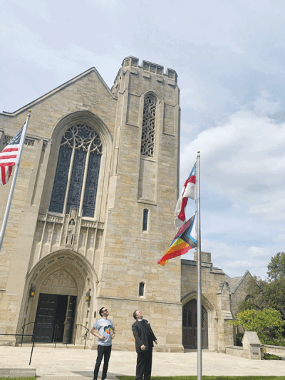  Christ Church Grosse Pointe Director of Music Scott Hanoian and the Rev. Andrew “Drew” Van Culin look at the new Progress Pride flag flying at the church after the previous flag was burned by an unknown person last week. 