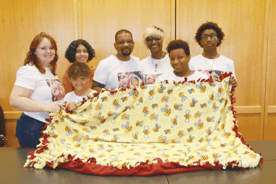  The family of Erin Terina Maria Patton pose with a blanket made at a Team Patton Outreach blanket drive in Clinton Township on Sept. 16. Patton died nearly 22 years ago to the day. 
