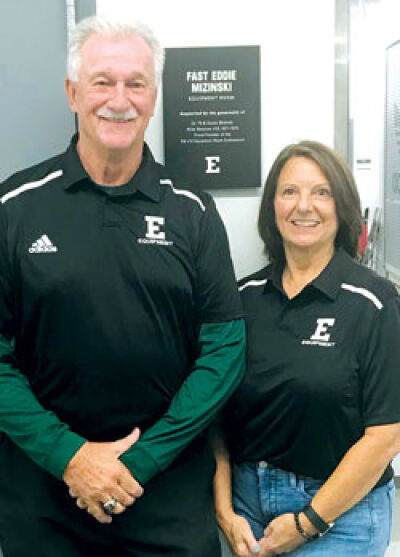  “Fast” Eddie Mizinski and his wife, Susan, who were high school sweethearts, stand in front of the Eastern Michigan University athletic equipment room named after Mizinski. 