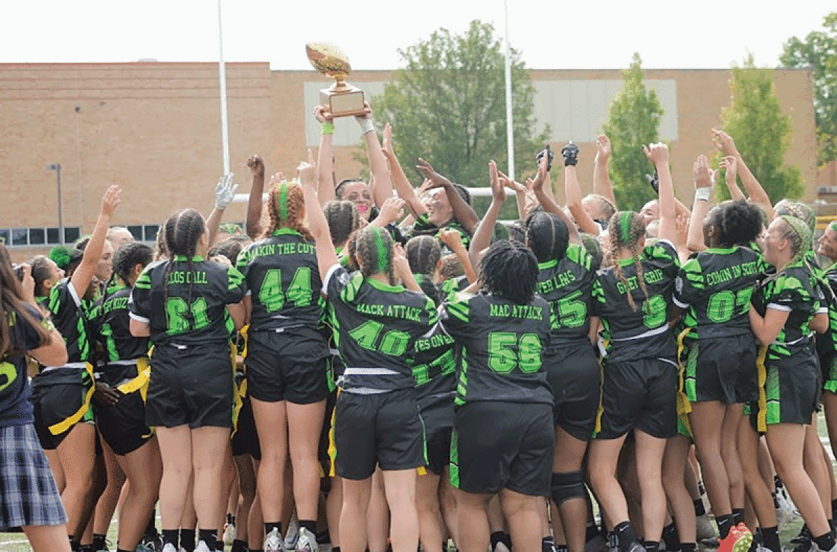  Regina celebrates with the trophy after a 14-7 win over Marian, extending  their win streak to seven and the overall  head-to-head record against Marian to  26-17 in favor of Regina. 