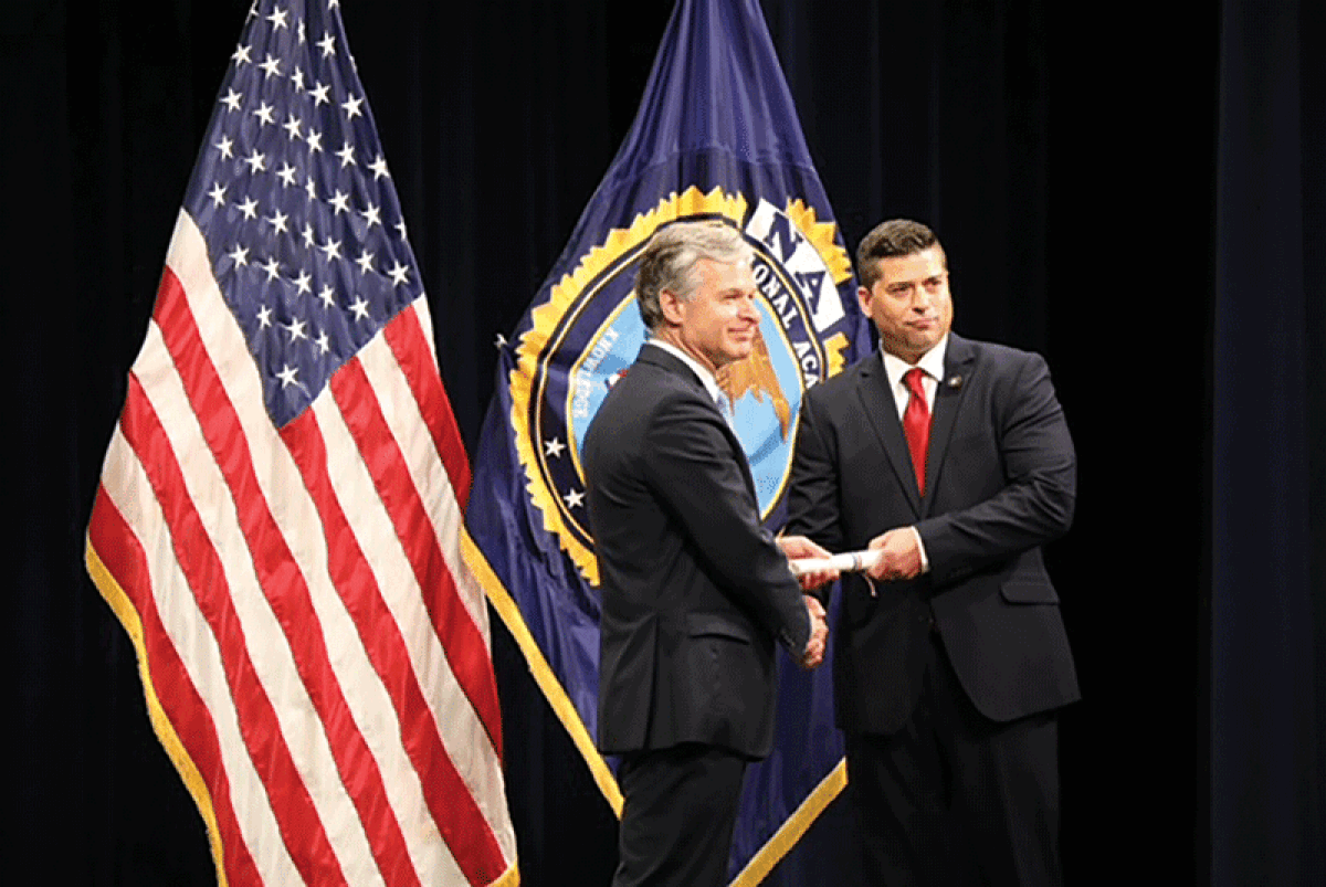  FBI director Christopher Wray shakes hands with Shelby Township Police Lt. Jeffrey Bellomo at the FBI National Academy graduation last month. 