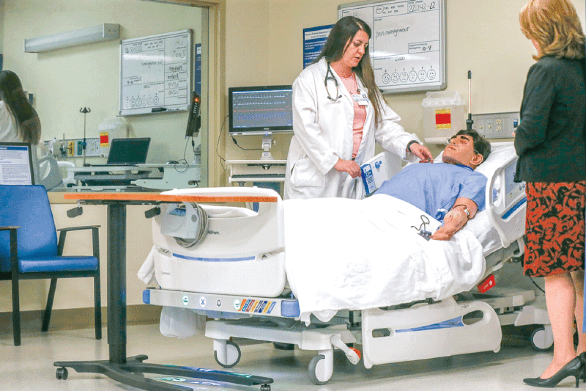  During the Oct. 2 ceremony, Meri Robinson, grants program director for Macomb Community College, left, works through a demonstration of the simulation with Andrea Shaw, the college’s associate dean of health and human services.  