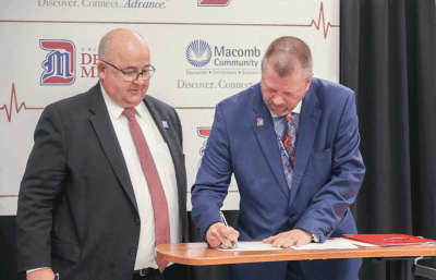  Macomb Community College President James Sawyer, left, and University of Detroit Mercy President Donald Taylor sign the BSN program agreement during a ceremony Oct. 2 on the Macomb Community College Center Campus in Clinton Township. 