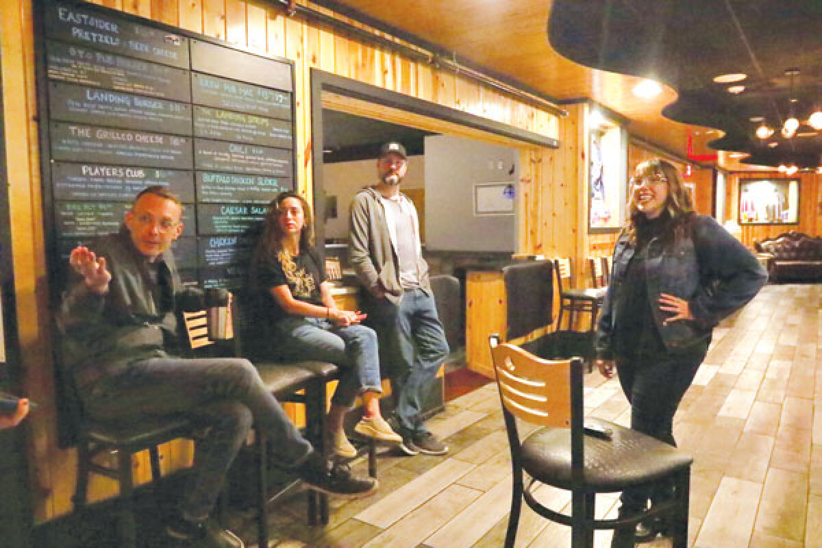  Employees speak about their paranormal experiences at Dragon’s Landing while Jessica Krutell, center, and Michael Miller, to the right of Krutell, listen in.  