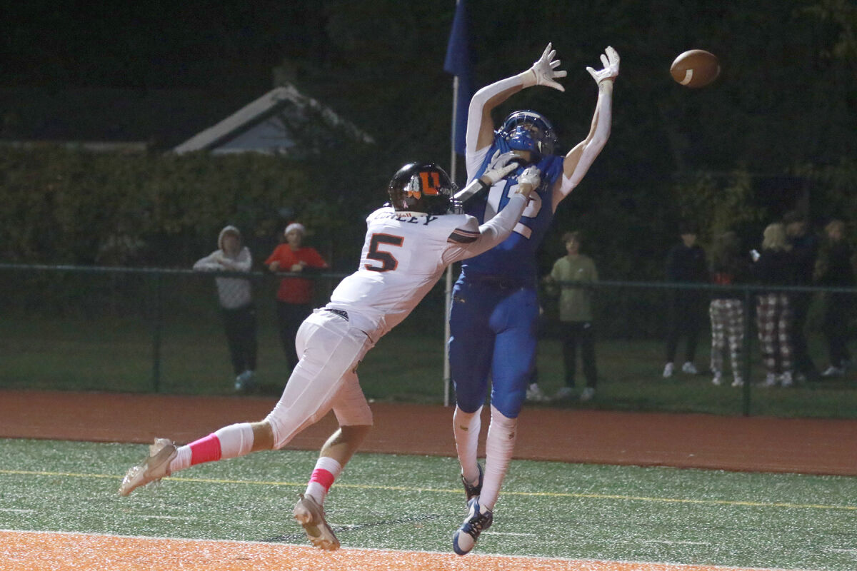  Eisenhower senior Hayden Bills (#12) attempts to make a leaping grab with Utica senior Zachary Conley (#5) in coverage. 