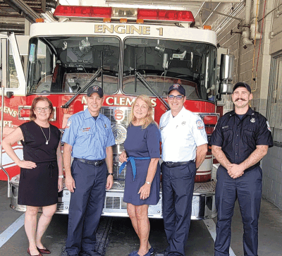  Mount Clemens Mayor Laura Kropp, left, and state Rep. Denise Mentzer pose in front of a fire truck with Mount Clemens Fire Department personnel. Mentzer helped Mount Clemens secure funding for a new fire engine.  