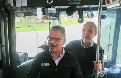  Oakland County Executive Dave Coulter, right, welcomes Oakland County Community College Chancellor Peter M. Provenzano Jr. onto the bus in Farmington Hills. 