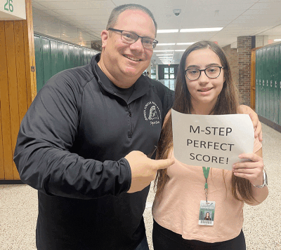  Bemis Junior High School eighth grader Isabella Bronzovich celebrates her perfect Michigan Student Test of Educational Progress math score with her former math teacher, Michael Galli. 