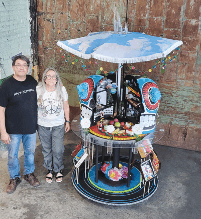  Ronald Rodriguez and his aunt, Mari Martin, stand beside their ofrenda, “Empty Chairs,” which is on display at the Detroit Institute of Arts’ “Ofrendas: Celebrating el Día de Muertos” exhibition. 