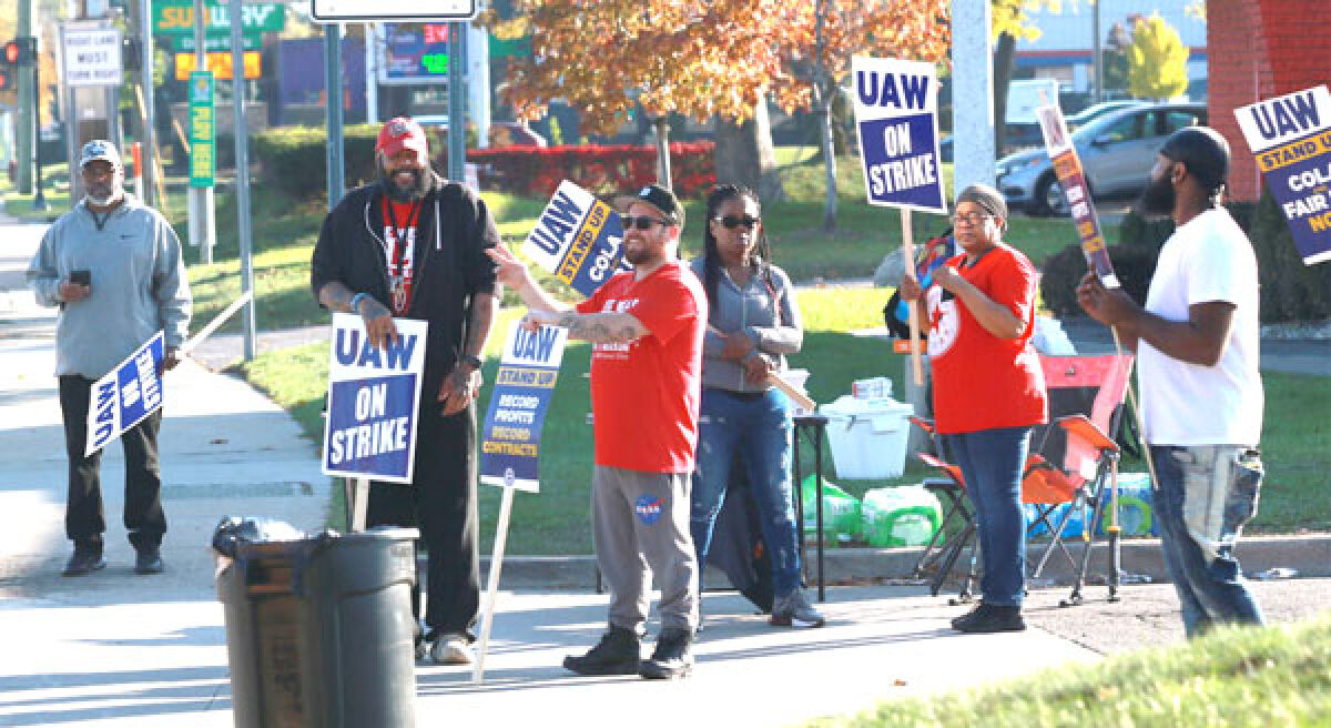  Demonstrators hold signs along Van Dyke Avenue near Metropolitan Parkway. 
