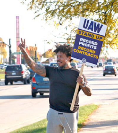 A demonstrator smiles at passing traffic. 