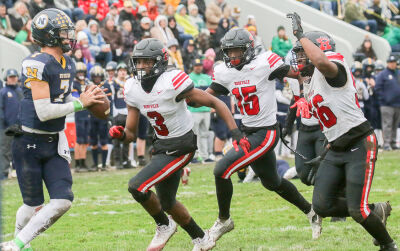  Roseville defenders Elijah Parker (#3), Anthony Scott (#15) and Michael Chude (#56) go after the Port Huron Northern quarterback. 