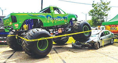  Reptoid, pictured in its green body, crushes a car at a prior KBW Gratiot Cruise Party. 