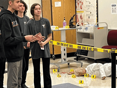  Students explain a simulated crime scene as part of a forensic unit. Forensic science is part of the public safety career path. 