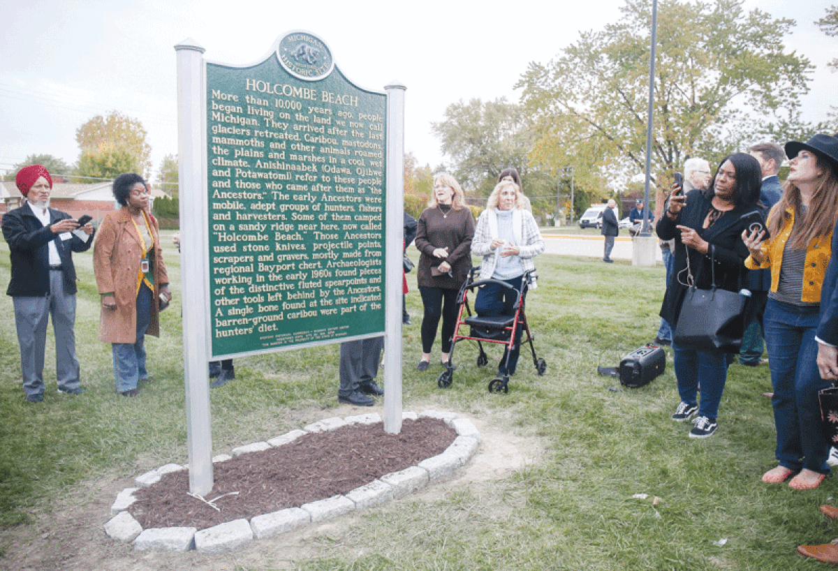  People attending the Holcombe Beach Historical Marker ceremony take pictures and read about the site’s history after the unveiling. 