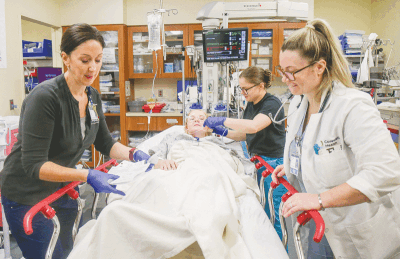  Registered nurse Lisa M., left and Dr. Meredith Colosi, right, tend to a victim with a simulated gunshot wound to the arm during a training simulation of a mass-shooting event.  