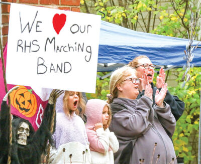  Donette Osorio, second from right, with family and friends, applauds during the performance on her front lawn. 