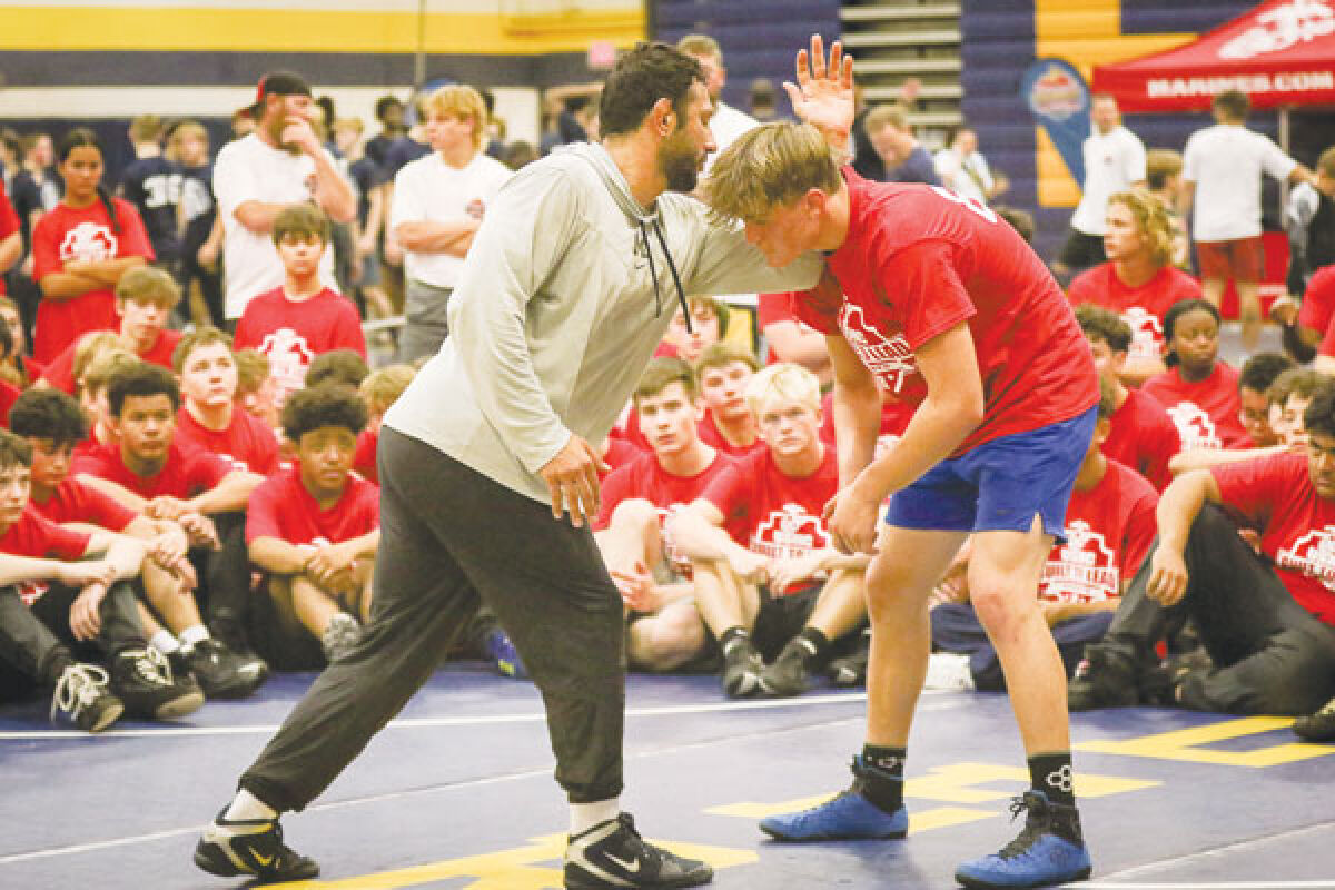  Former University of Michigan wrestler and Olympic medalist Myles Amine demonstrates a move during the wrestling camp. 