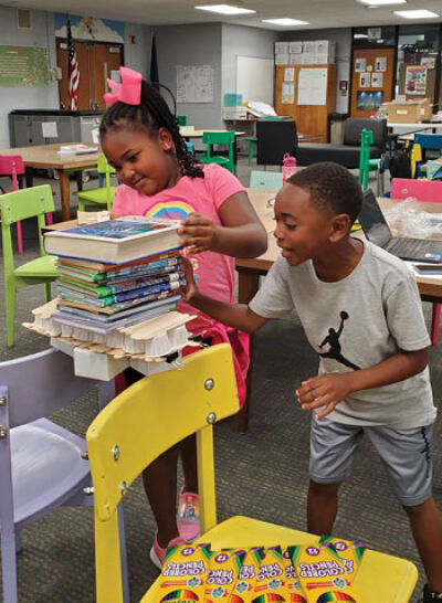  Eastpointe Community Schools students in the STEM literacy and learning program test the strength of their popsicle stick bridges. 