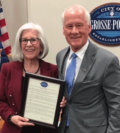  During an Oct. 16 Grosse Pointe City Council meeting in council chambers — which also serve as the municipal courtroom —  Mayor Sheila Tomkowiak presents outgoing City Municipal Court Judge Russell Ethridge with a proclamation in his honor. 