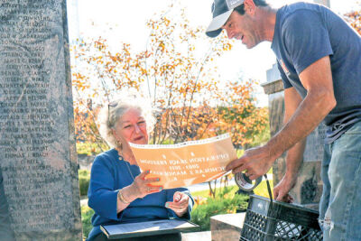  Manoukian looks over the stencil of what will be engraved before Brent Clover, of Clover Stones, sandblasts the name onto the memorial bench.  