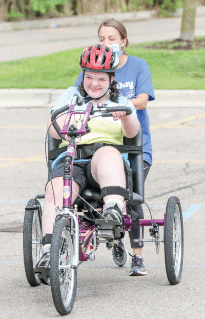  Kathleen Warden, a 19-year-old from Berkley, speeds off on her new bike while Beaumont speech pathologist Katie Laperriere tries to keep up. This is the third bike Warden has received through Bike Day, having received the first when she was 4-years-old. 