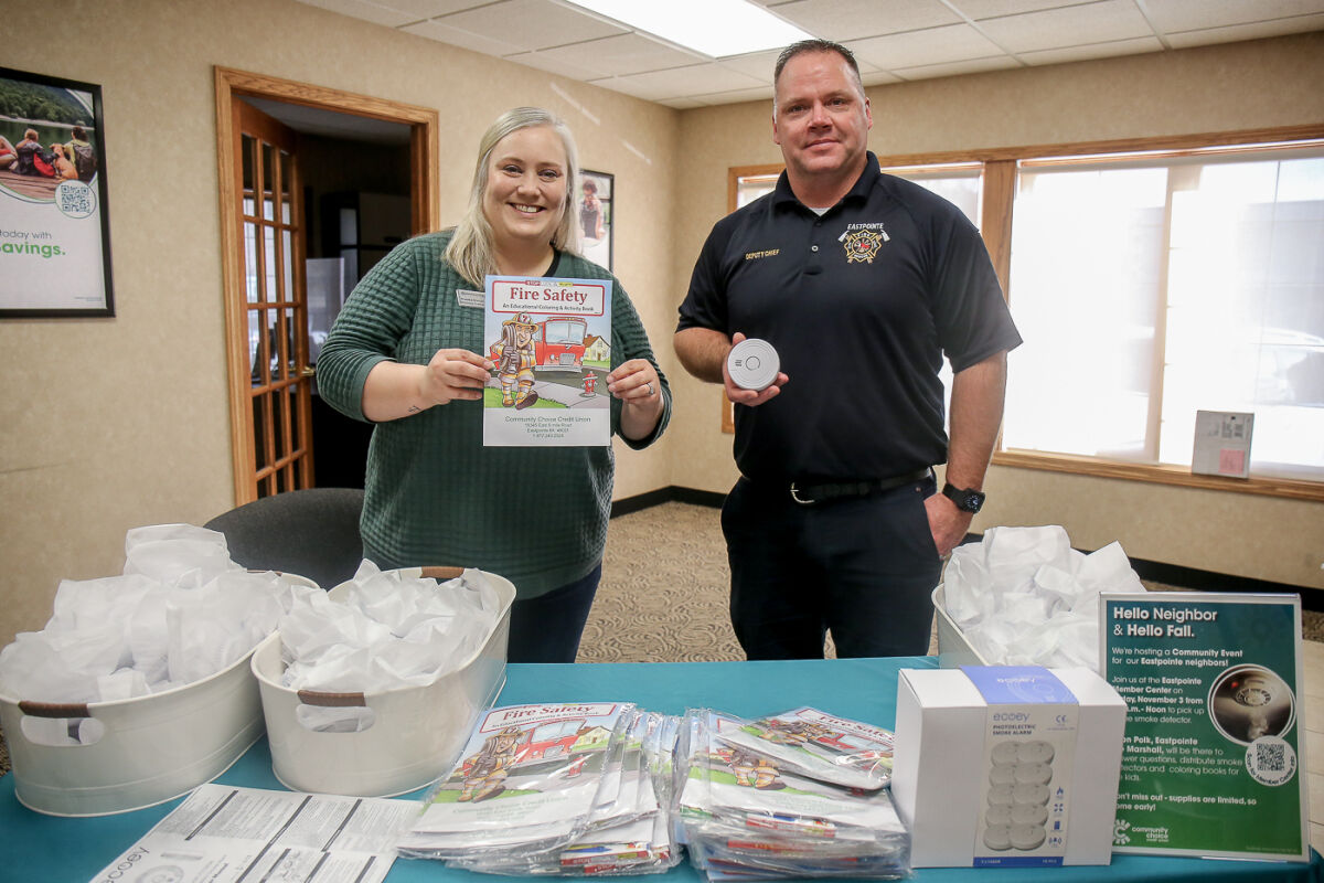  Community Choice Credit Union member center manager Brooke Bieber and Eastpointe Fire Marshal Alton Polk distribute smoke detectors and fire safety coloring books Nov. 3. 