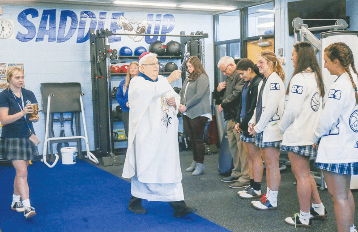  On Nov. 1, Bishop John Quinn blesses the new weight room at Regina High School in Warren.  