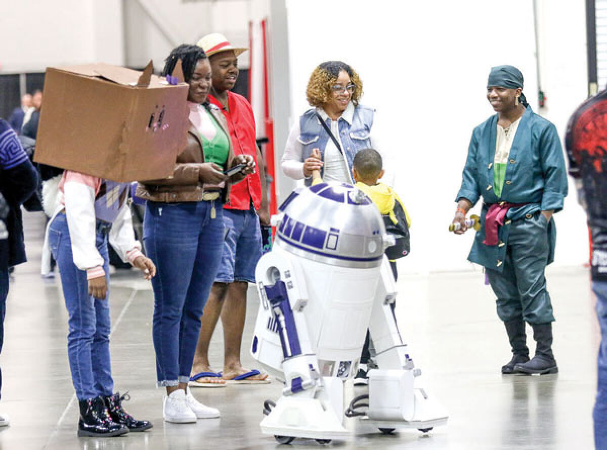  Attendees of the fall Motor City Comic Con enjoy a visit with R2-D2 from “Star Wars.” 