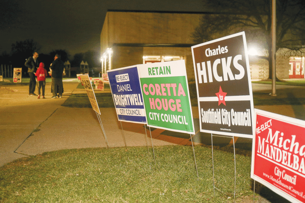  Signs with candidate names adorn the lawn of Thompson K-8 International Academy as voters head inside to make their decisions.  