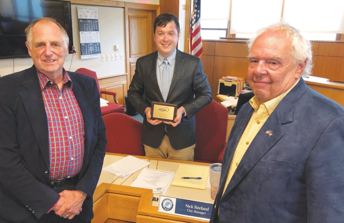  Grosse Pointe Park City Manager Nick Sizeland, center, is honored by American Society for Public Administration’s Detroit Metropolitan Area Board members, from left, Donald Crawford and Mark Wollenweber during a July 18 Park City Council meeting. 