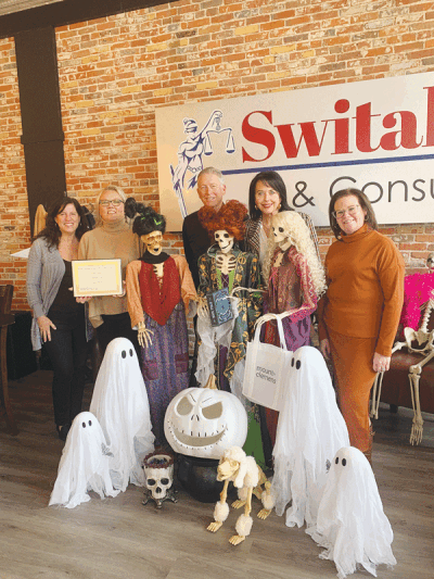  Members of Switalski Law pose with Mount Clemens Mayor Laura Kropp and the firm’s “Hocus Pocus” skeleton display.  
