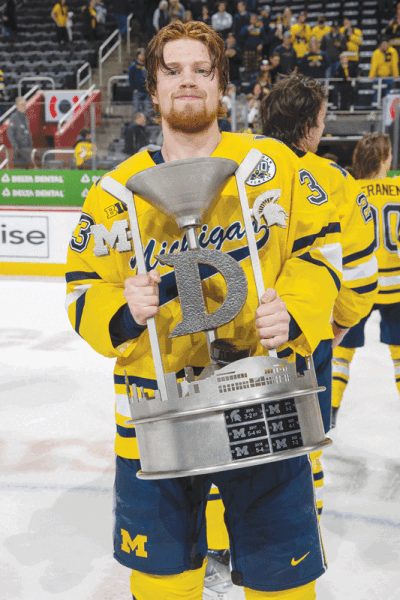  University of Michigan forward Kienan Draper holds the “Iron D” Trophy after a 4-3 win over Michigan State University on Feb. 11 at Little Caesars Arena. 