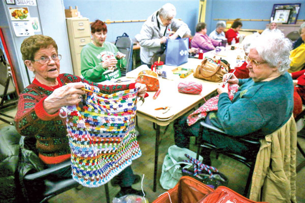  Women of the knitting and crocheting group make their projects and show them off. 